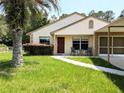 Inviting front entrance with seating, a well-manicured lawn, and charming curb appeal at 21298 Sw Peach Blossom St, Dunnellon, FL 34431