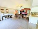 Open-concept living area featuring modern tile flooring, stylish decor, and a kitchen view at 21298 Sw Peach Blossom St, Dunnellon, FL 34431