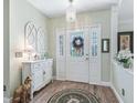 Inviting foyer with hardwood floors, decorative mirror, and ample natural light from the decorative glass front door at 2478 Nw 53Rd Avenue Rd, Ocala, FL 34482