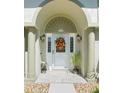 Inviting front door framed by elegant columns, with a decorative wreath and charming outdoor lighting at 2478 Nw 53Rd Avenue Rd, Ocala, FL 34482