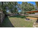 Expansive backyard featuring a covered deck, fire pit, and mature shade trees at 3065 Se 142Nd Ln, Summerfield, FL 34491