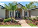 Attractive home entrance with stone accents, palm trees, and a well-maintained walkway at 3612 Se 47Th Ter, Ocala, FL 34480