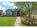 Charming single-story home featuring a stone facade, mature trees, and a well-manicured lawn at 3612 Se 47Th Ter, Ocala, FL 34480