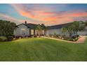 Stunning home exterior with lush lawn, manicured landscaping, and a beautiful sunset backdrop at 3612 Se 47Th Ter, Ocala, FL 34480