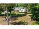 Charming two-story home with dormer windows, lush front lawn, and mature trees providing shade at 645 Sw 48Th Ln, Ocala, FL 34471
