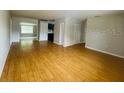 The cozy living room has shiny hardwood floors and is brightly lit from the windows at 6820 Se 108Th St, Belleview, FL 34420