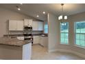 Well-lit kitchen boasts white cabinetry, stainless steel appliances, and a cozy nook area with natural light at 74 Pine Trace Crse, Ocala, FL 34472