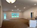 Bright living room features an open layout, recessed lighting, and an adjacent kitchen with a breakfast bar at 74 Pine Trace Crse, Ocala, FL 34472