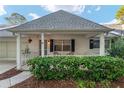 Inviting front porch with manicured hedges, brick accents, and cozy seating at 8681 Sw 93Rd Pl # B, Ocala, FL 34481