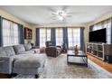 Comfortable living room with plush seating, a ceiling fan, and large windows for natural light at 8973 Sw 103Rd Ln, Ocala, FL 34481