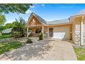 Inviting villa exterior with attached garage, walkway, and lush, green landscaping at 9330 Sw 84Th Ter # A, Ocala, FL 34481