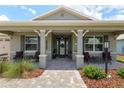 Inviting front porch with comfortable seating, decorative columns, and brick pathway at 9577 Sw 82Nd Street Rd, Ocala, FL 34481
