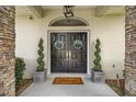 Covered entryway with double doors, decorative wreaths, and spiral topiary accents at 1107 Se 49Th Ave, Ocala, FL 34471