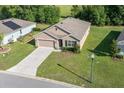 A high-angle view shows a charming, single-story home with well-maintained landscaping in a suburban neighborhood at 160 Hickory Course Loop, Ocala, FL 34472