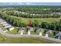 This aerial shot highlights a neighborhood home situated near trees and an open field with scenic surroundings at 160 Hickory Course Loop, Ocala, FL 34472