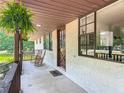 Inviting front porch with rocking chairs, dark wood trim, and a large window, perfect for relaxing at 2580 Se 157Th Lane Rd, Summerfield, FL 34491