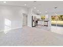 Bright open-concept living room and kitchen with stainless steel appliances and sliding glass door at 315 Sw 140 Ave, Ocala, FL 34481