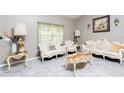 Inviting living room with light gray floors, large windows, and classic furniture at 340 Oak Track Loop, Ocala, FL 34472