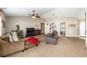 Comfortable living room with plush carpeting, ceiling fan, and neutral color palette at 3887 Sw 156Th Pl, Ocala, FL 34473