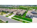 An aerial view shows a lovely home with a manicured lawn in a neighborhood with a well maintained green spaces at 5248 Red Coral Cir, Mount Dora, FL 32757
