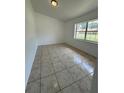 Neutral bedroom with window and tile flooring at 5525 Se 43Rd Ct, Ocala, FL 34480