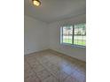 Bright bedroom featuring neutral walls, a large window, and ceramic tile floors at 5525 Se 43Rd Ct, Ocala, FL 34480