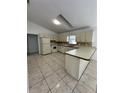 Kitchen with tile flooring, white cabinetry, countertops, and natural lighting at 5525 Se 43Rd Ct, Ocala, FL 34480