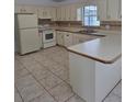 Classic kitchen featuring white cabinets, tile backsplash, and modern appliances at 5525 Se 43Rd Ct, Ocala, FL 34480