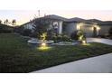 Well-manicured lawn and illuminated landscaping enhance the curb appeal of this lovely single-story home at 5634 Sw 91St Ave, Ocala, FL 34481