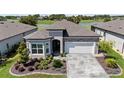 Beautiful single-story home showcases stone accents, a manicured lawn, and a water view at 5728 Sw 90Th Court Rd, Ocala, FL 34481
