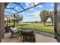 Relaxing screened porch overlooks a lush green lawn and tranquil lake, perfect for outdoor enjoyment at 5728 Sw 90Th Court Rd, Ocala, FL 34481