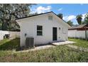 Back exterior featuring a well-kept white exterior and a small patio area at 719 Nw 8Th St, Ocala, FL 34475