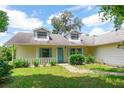 A charming single-Gathering home featuring a light yellow exterior with light blue trim and a well-maintained front yard at 8 Juniper Pass Way, Ocala, FL 34480