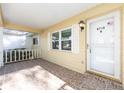 Inviting front porch with tiled flooring, white railing, and an entry door with an American flag sticker at 8710 Sw 91St Pl # B, Ocala, FL 34481