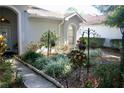 Beautifully landscaped front yard with manicured bushes, plants, decorative wrought iron, and a sidewalk at 8735 Sw 192Nd Court Rd, Dunnellon, FL 34432
