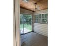 Enclosed sun room with sliding glass door, wood ceiling, ceiling fan and weathered tile floor at 922 Se 13Th St, Ocala, FL 34471