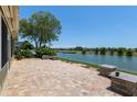 Paver patio has stone accents and overlooks a lake for a relaxing backyard view at 9511 Sw 71St Loop, Ocala, FL 34481