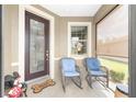 Inviting front porch with comfortable seating, decorative door, and a view of the yard at 9658 Sw 76Th Lane Rd, Ocala, FL 34481