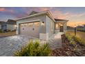 Inviting single-Gathering home featuring a two-car garage and well-maintained landscaping at sunset at 10277 Sw 96Th Loop, Ocala, FL 34481