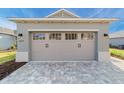 Two car garage door on a single-Gathering home with a brick driveway at 10277 Sw 96Th Loop, Ocala, FL 34481