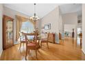 Bright dining room with hardwood floors, a glass table, and elegant chandelier at 11147 Sw 53Rd Cir, Ocala, FL 34476