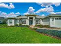 Attractive single-story home with a well-manicured lawn, colorful landscaping, and a two-car garage at 11147 Sw 53Rd Cir, Ocala, FL 34476