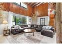 Inviting living room featuring a large sectional sofa, wood paneled walls and natural light at 11170 Sw 190Th Ave, Dunnellon, FL 34432