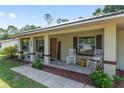Inviting front porch with rocking chairs and tasteful decor enhances the curb appeal of this lovely home at 1601 Ne 47Th Ct, Ocala, FL 34470