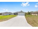 Contemporary one-story home with a long driveway and attached two-car garage at 16697 Sw 30 Avenue Rd, Ocala, FL 34473