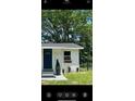 Beautifully landscaped white home with a dark blue door and well-manicured yard at 1705 Nw 18Th Ave, Ocala, FL 34475