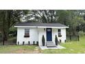 Cute white home with a dark blue door, flower boxes, landscaped bushes and a black fence at 1705 Nw 18Th Ave, Ocala, FL 34475