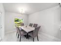 Bright dining room featuring an elegant marble table, six chairs, modern lighting and wood look tile flooring at 181 Nw 45Th Loop, Ocala, FL 34475