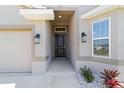 Inviting front entryway with a sleek black door, manicured landscaping, and stylish exterior lighting at 181 Nw 45Th Loop, Ocala, FL 34475