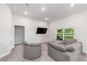 Cozy living area with a comfortable gray sectional, a large window, and recessed lighting at 181 Nw 45Th Loop, Ocala, FL 34475